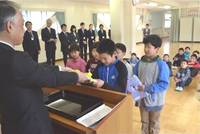 守下校長(左)から教科書を受け取る児童 守下校長(左)から教科書を受け取る児童