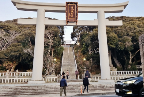 海岸に建つ鳥居と早朝の参拝