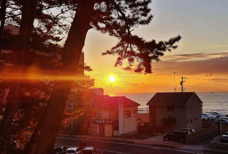 海岸に建つ鳥居と早朝の参拝